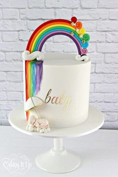 a white cake with rainbow decoration on top