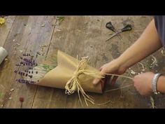 someone is wrapping some flowers in brown paper