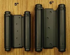 four black plastic doors with holes in them on a wooden surface next to measuring tape