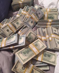 a pile of money sitting on top of a bed