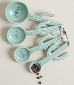 four measuring spoons with the words i love you on them and bead necklace