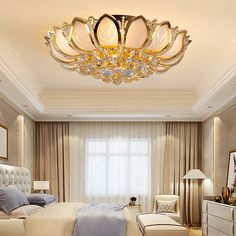 a large bed sitting under a fancy chandelier in a bedroom next to a window