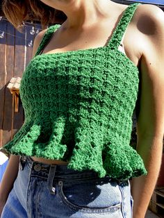 a woman is wearing a green crochet top