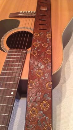 a guitar strap with flowers on it