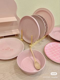 pink dishes with wooden spoons are arranged on a table