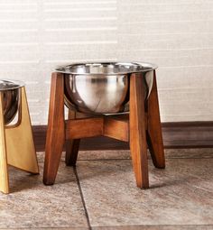 two stainless steel bowls sitting on wooden stands