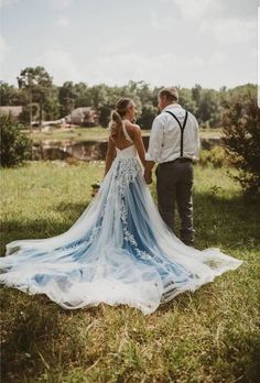 a bride and groom are standing in the grass