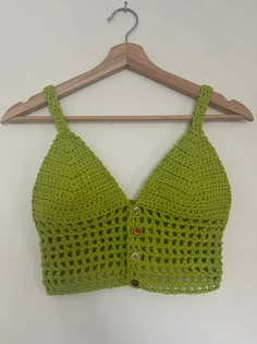 a crocheted bra hanging on a wooden hanger