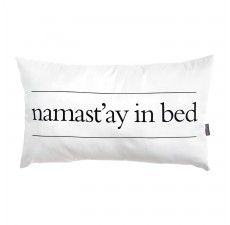 a white pillow with the words namastay in bed printed on it