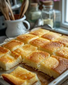 a pan filled with sliced bread on top of a counter next to utensils