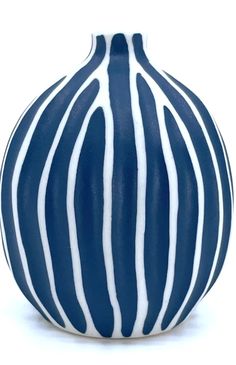 a blue and white striped vase sitting on top of a table