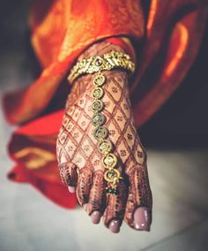 a woman's hand with henna and bracelets on it