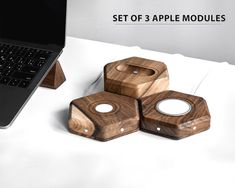 four wooden coasters sitting next to a laptop on a desk with the words set of 3 apple modulares