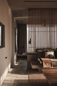 a living room filled with lots of furniture next to a wall covered in bamboo blinds