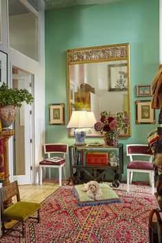 a living room filled with furniture and a dog laying on top of a rug in front of a mirror