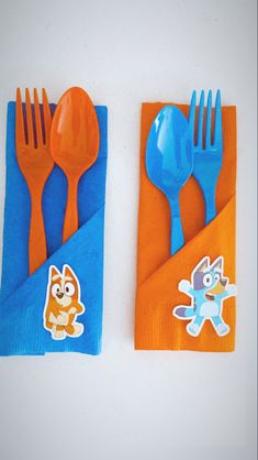 two orange and blue napkins with cartoon cats on them are sitting next to each other