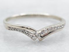 a white gold wedding ring with three diamonds on it's side, set in 18k white gold