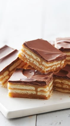 several pieces of cake on a plate with chocolate frosting and peanut butter bars in the middle