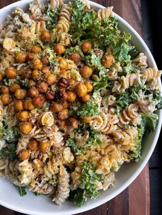 pasta salad with chickpeas and broccoli in a white bowl on a wooden table