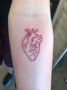 a small heart tattoo on the arm