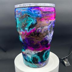 a colorful glass sitting on top of a white stand