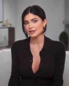 an image of a woman sitting on a couch with her hands in her pockets and looking at the camera