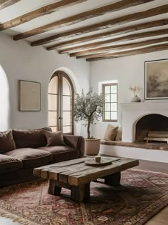 a living room filled with furniture and a fire place next to a couch on top of a rug