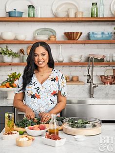 a woman standing in front of a counter with food on it and bowls around her