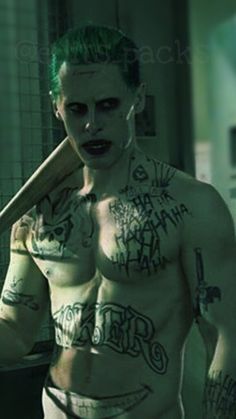 a shirtless man with green hair and tattoos holding a baseball bat in his hand