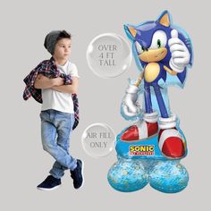 a young boy standing next to an inflatable sonic the hedgehog character balloon