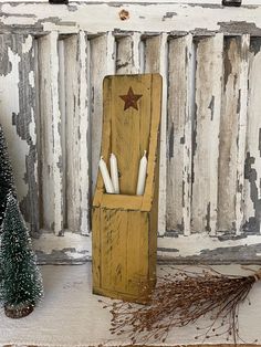 an old wooden box with pens in it next to a christmas tree and other decorations