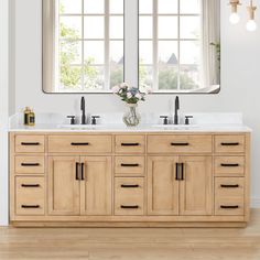 a bathroom vanity with two mirrors above it and flowers in the vase on the counter