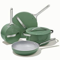 an assortment of green pots and pans on a white background with one empty pan