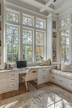 a home office with lots of windows and white furniture