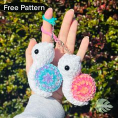 a hand holding two small crocheted birds in it's palm, with the text free pattern