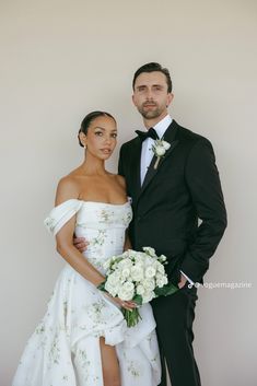 a man and woman in formal wear posing for the camera with their wedding bouquets