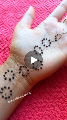 a person's hand with some black beads on it