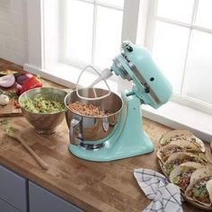 a kitchen counter topped with bowls and mixers filled with food next to cutting boards