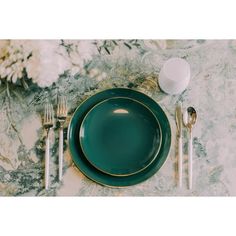 a table setting with green plates and silverware