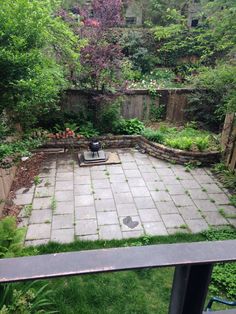 an outdoor patio with stone pavers and trees in the background