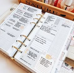 an open planner book sitting on top of a table next to some pens and pencils