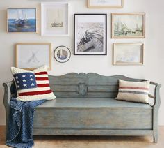 a blue couch with pillows and pictures on the wall