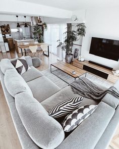 a living room filled with furniture and a large flat screen tv mounted to the wall