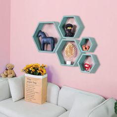 a living room filled with furniture and wall mounted shelving units on the wall next to a white couch