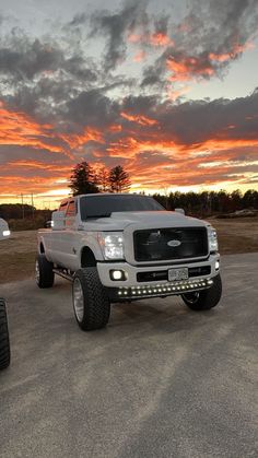 a white truck parked in a parking lot at sunset