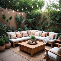 an outdoor living area with couches, tables and potted plants