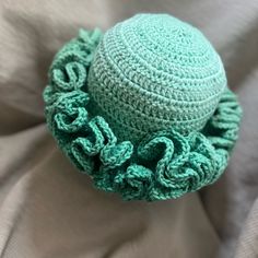 a crocheted green hat with ruffles on it's brim