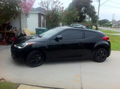 a black sports car parked in front of a house