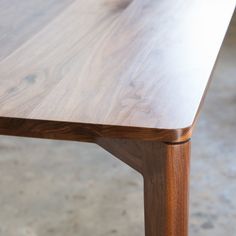 a wooden table sitting on top of a cement floor