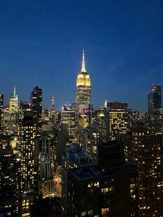 the city skyline is lit up at night, with skyscrapers in the foreground